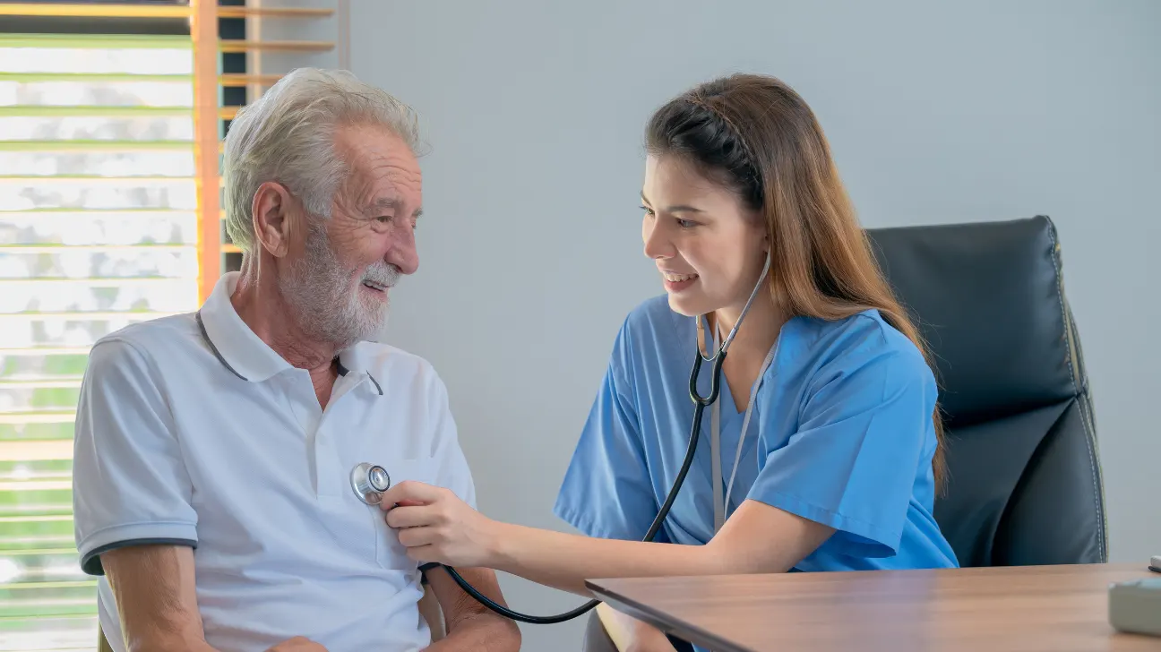 Doctor examining the heart health of and aged old man